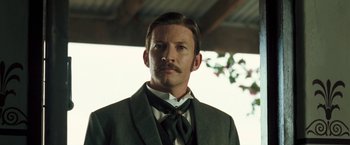 Movie still from “The Proposition” (2005), directed by John Hillcoat – A man with a mustache wearing a suit and tie; Close Up shot, Low angle