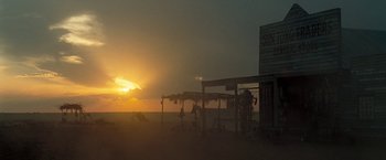 Movie still from “The Proposition” (2005), directed by John Hillcoat – People are gathered on the beach at sunset; Extreme Wide shot, Low angle