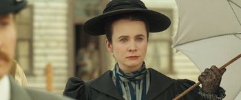Movie still from “The Proposition” (2005), directed by John Hillcoat – A woman wearing a black hat and a striped scarf; Close Up shot, Over the shoulder angle