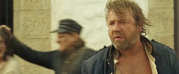 Movie still from “The Proposition” (2005), directed by John Hillcoat – A man with a beard is standing next to another man; Close Up shot, Over the shoulder angle