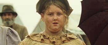 Movie still from “The Proposition” (2005), directed by John Hillcoat – A young girl wearing a hat and a dress; Close Up shot, Low angle