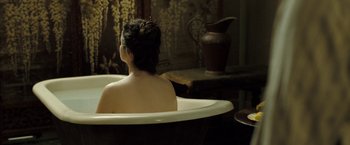 Movie still from “The Proposition” (2005), directed by John Hillcoat – A woman sitting in a bath tub in front of a vase; Medium shot, High angle