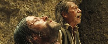 Movie still from “The Proposition” (2005), directed by John Hillcoat – A man with a beard and a man with long hair; Close Up shot, Low angle