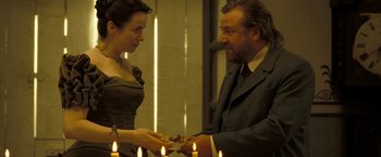 Movie still from “The Proposition” (2005), directed by John Hillcoat – A man and a woman are holding a plate of food; Medium shot, Over the shoulder angle