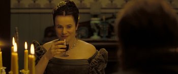 Movie still from “The Proposition” (2005), directed by John Hillcoat – A woman holding a glass of wine in her hand; Close Up shot, Over the shoulder angle