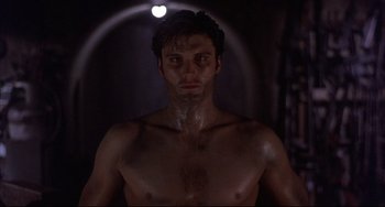 Movie still from “The Punisher” (1989), directed by Mark Goldblatt – A man with no shirt in a dark room; Close Up shot, Low angle