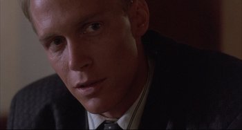 Movie still from “The Punisher” (1989), directed by Mark Goldblatt – A person wearing a suit and tie; Close Up shot, Low angle