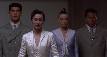 Movie still from “The Punisher” (1989), directed by Mark Goldblatt – A couple of women standing next to each other in a room; Medium shot, Low angle