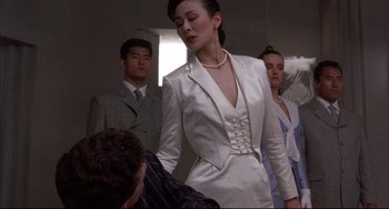 Movie still from “The Punisher” (1989), directed by Mark Goldblatt – A woman in a white dress standing in front of a man; Medium shot, Low angle