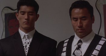 Movie still from “The Punisher” (1989), directed by Mark Goldblatt – Two men in suits and ties standing next to each other; Close Up shot, Low angle