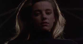 Movie still from “The Punisher” (1989), directed by Mark Goldblatt – A woman with long blonde hair is in the dark; Close Up shot, Low angle