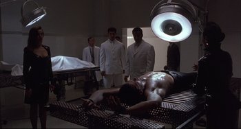 Movie still from “The Punisher” (1989), directed by Mark Goldblatt – A group of men standing next to each other in a room; Wide shot, High angle