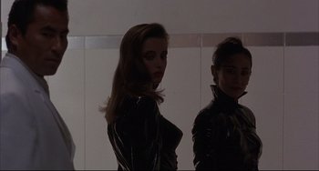 Movie still from “The Punisher” (1989), directed by Mark Goldblatt – Two women in leather jackets standing next to each other in a room; Medium shot, Low angle