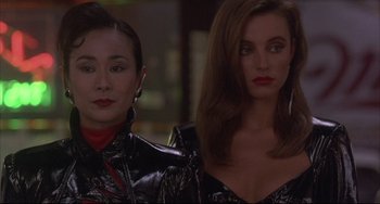 Movie still from “The Punisher” (1989), directed by Mark Goldblatt – Two women in black and red outfits standing next to each other; Close Up shot, Low angle