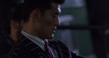 Movie still from “The Punisher” (1989), directed by Mark Goldblatt – A person wearing a suit and tie; Close Up shot, Over the shoulder angle