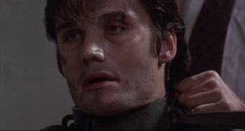 Movie still from “The Punisher” (1989), directed by Mark Goldblatt – A person with wet hair; Close Up shot, Over the shoulder angle