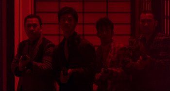 Movie still from “The Punisher” (1989), directed by Mark Goldblatt – A group of men standing next to each other holding guns; Medium shot, Low angle