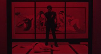 Movie still from “The Punisher” (1989), directed by Mark Goldblatt – A man standing in front of a woman lying on the ground; Wide shot, High angle