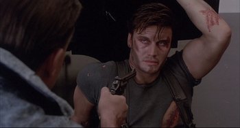Movie still from “The Punisher” (1989), directed by Mark Goldblatt – A man holding a gun in his hand; Close Up shot, Over the shoulder angle