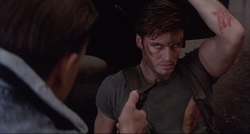 Movie still from “The Punisher” (1989), directed by Mark Goldblatt – A man is looking at another man with a knife; Close Up shot, Over the shoulder angle