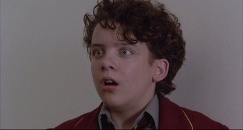 Movie still from “The Punisher” (1989), directed by Mark Goldblatt – A young man with curly brown hair looking surprised; Close Up shot, Low angle