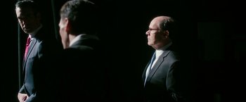 Movie still from “The Purge: Election Year” (2016), directed by James DeMonaco – An older man wearing a suit and tie; Medium shot, Over the shoulder angle