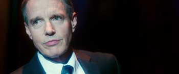 Movie still from “The Purge: Election Year” (2016), directed by James DeMonaco – A person wearing a suit and tie; Close Up shot, Low angle