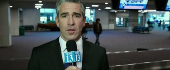 Movie still from “The Purge: Election Year” (2016), directed by James DeMonaco – A man in a suit and tie holding a microphone; Close Up shot, Over the shoulder angle