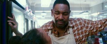 Movie still from “The Purge: Election Year” (2016), directed by James DeMonaco – A man wearing an apron is looking down at a child; Close Up shot, Over the shoulder angle