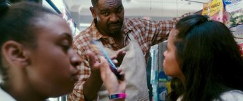 Movie still from “The Purge: Election Year” (2016), directed by James DeMonaco – A man in an apron holding a toothbrush in a store; Medium shot, Over the shoulder angle