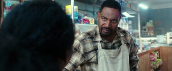 Movie still from “The Purge: Election Year” (2016), directed by James DeMonaco – A man wearing an apron is talking to a woman; Close Up shot, Over the shoulder angle