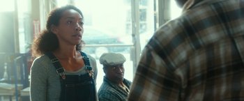 Movie still from “The Purge: Election Year” (2016), directed by James DeMonaco – A group of people sitting in front of a window; Medium shot, Over the shoulder angle