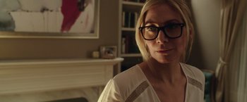 Movie still from “The Purge: Election Year” (2016), directed by James DeMonaco – A woman wearing glasses in a room with a fire place; Close Up shot, Over the shoulder angle