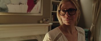 Movie still from “The Purge: Election Year” (2016), directed by James DeMonaco – A woman wearing glasses in a room with a fire place; Close Up shot, Over the shoulder angle