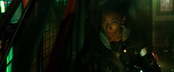 Movie still from “The Purge: Election Year” (2016), directed by James DeMonaco – A woman is standing in a dark room; Close Up shot, Over the shoulder angle