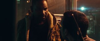 Movie still from “The Purge: Election Year” (2016), directed by James DeMonaco – A man in a brown jacket standing next to another man in a brown jacket; Close Up shot, Over the shoulder angle