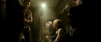 Movie still from “The Purge: Election Year” (2016), directed by James DeMonaco – A group of people sitting in a small room; Medium shot, Over the shoulder angle