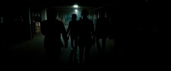 Movie still from “The Purge: Election Year” (2016), directed by James DeMonaco – A group of people walking down a dark hallway; Wide shot, Low angle