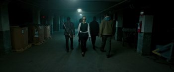 Movie still from “The Purge: Election Year” (2016), directed by James DeMonaco – A group of people walking down a dark hallway; Wide shot, Low angle