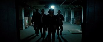 Movie still from “The Purge: Election Year” (2016), directed by James DeMonaco – A group of people walking in a dark room; Wide shot, Low angle