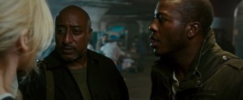 Movie still from “The Purge: Election Year” (2016), directed by James DeMonaco – Two men standing next to each other in a room; Close Up shot, Over the shoulder angle