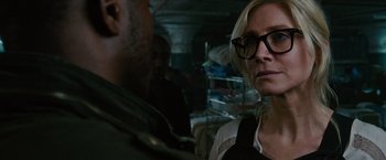 Movie still from “The Purge: Election Year” (2016), directed by James DeMonaco – A woman wearing glasses is looking at a man in glasses; Close Up shot, Over the shoulder angle