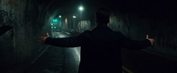 Movie still from “The Purge: Election Year” (2016), directed by James DeMonaco – A man standing in a tunnel with his arms outstretched; Wide shot, Low angle