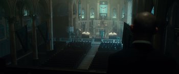 Movie still from “The Purge: Election Year” (2016), directed by James DeMonaco – A large church with many pews and a large window; Wide shot, Over the shoulder angle