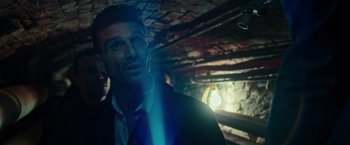 Movie still from “The Purge: Election Year” (2016), directed by James DeMonaco – A man in a suit and tie in a room with brick walls; Close Up shot, Low angle