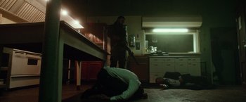 Movie still from “The Purge: Election Year” (2016), directed by James DeMonaco – Two men are lying on the floor in a kitchen; Wide shot, Low angle