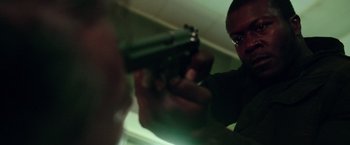 Movie still from “The Purge: Election Year” (2016), directed by James DeMonaco – A man is holding a gun in a room; Close Up shot, Low angle