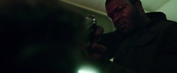 Movie still from “The Purge: Election Year” (2016), directed by James DeMonaco – A man holding a gun in a dark room; Close Up shot, Low angle