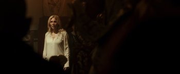 Movie still from “The Purge: Election Year” (2016), directed by James DeMonaco – A woman standing in front of a mirror in a dark room; Medium shot, Over the shoulder angle