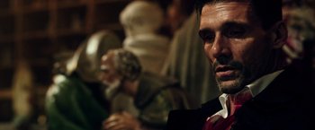 Movie still from “The Purge: Election Year” (2016), directed by James DeMonaco – A person wearing a suit and tie; Close Up shot, Over the shoulder angle